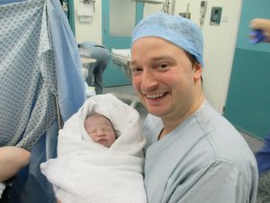 man and new born baby after c-section