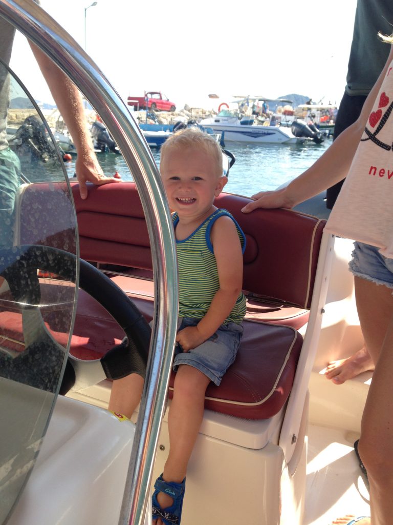 toddler at wheel of boat