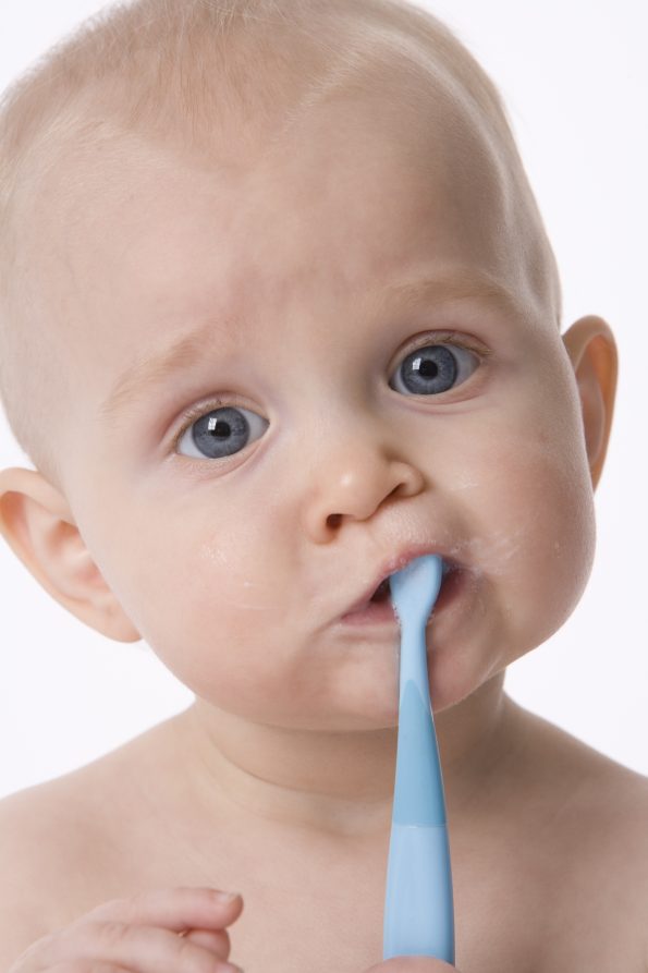 baby with toothbrush in it's mouth