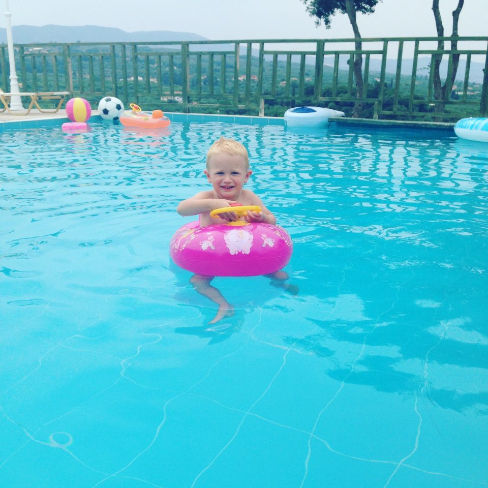 child in a floating car in a pool