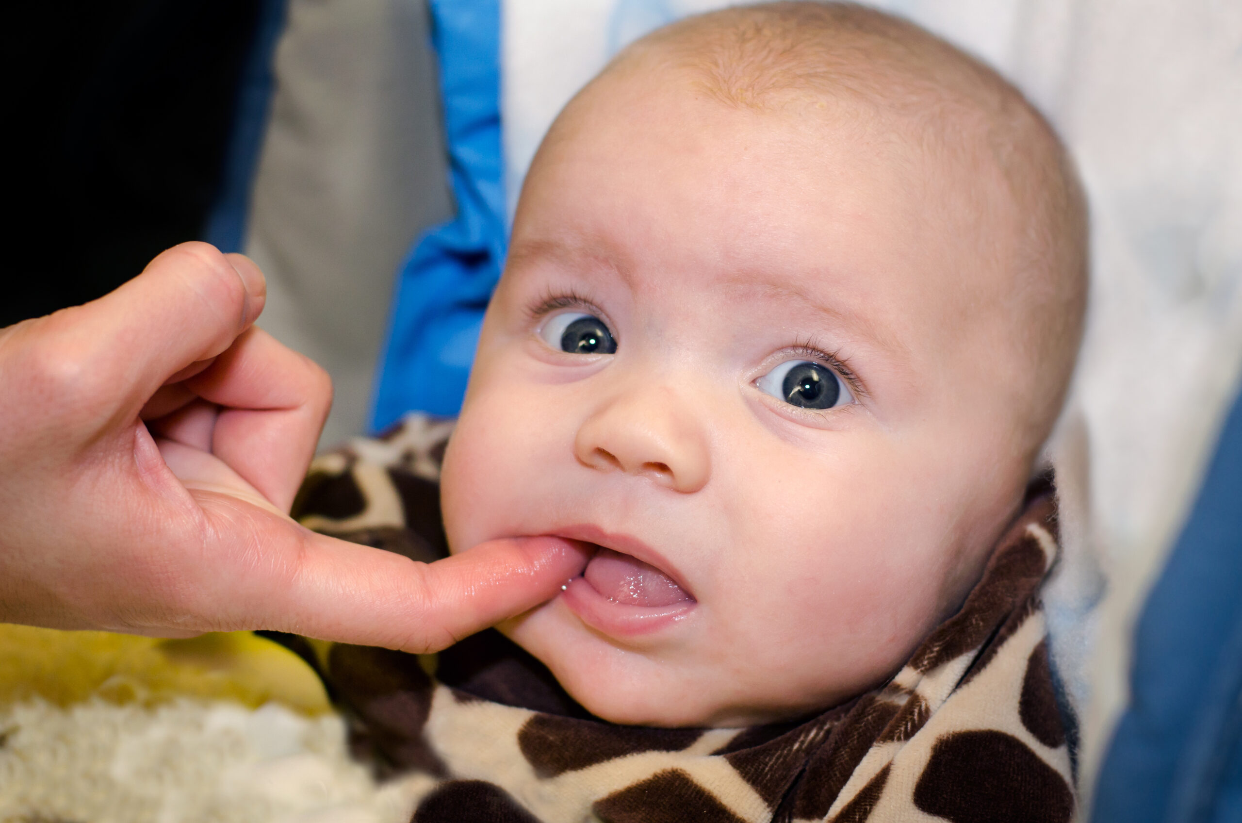 teething baby with finger in his mouth