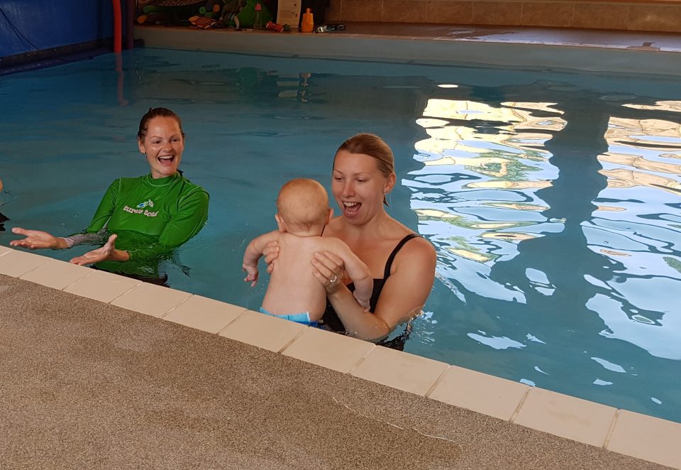 Mum jumping baby in the water in a pool