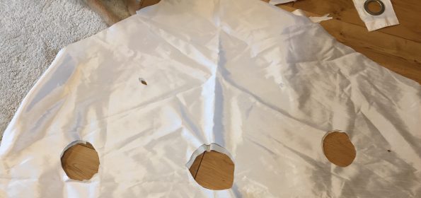 the curtain laid out on the floor with the head hole and two armholes cut out