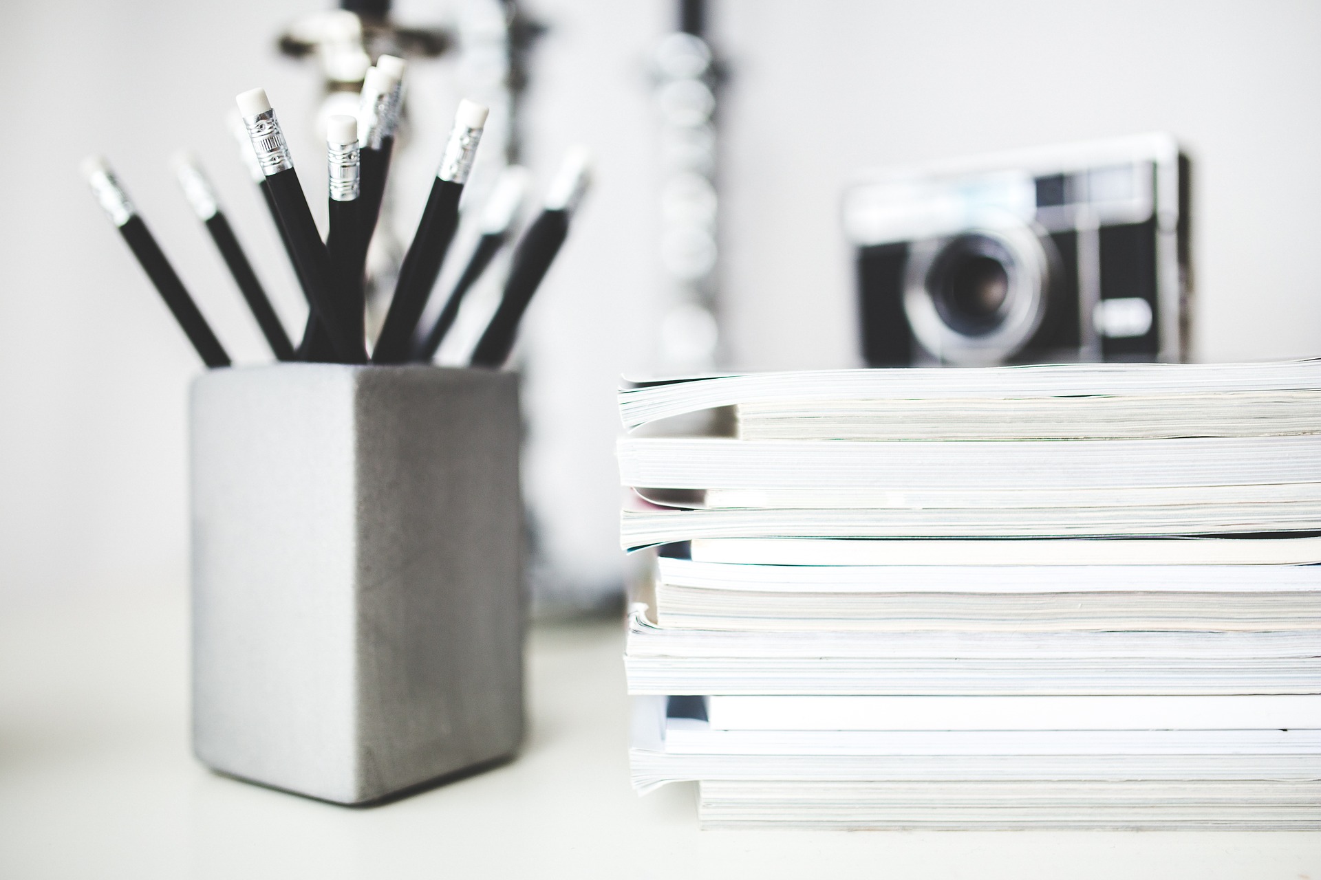 pencils and books and a camera in black and white