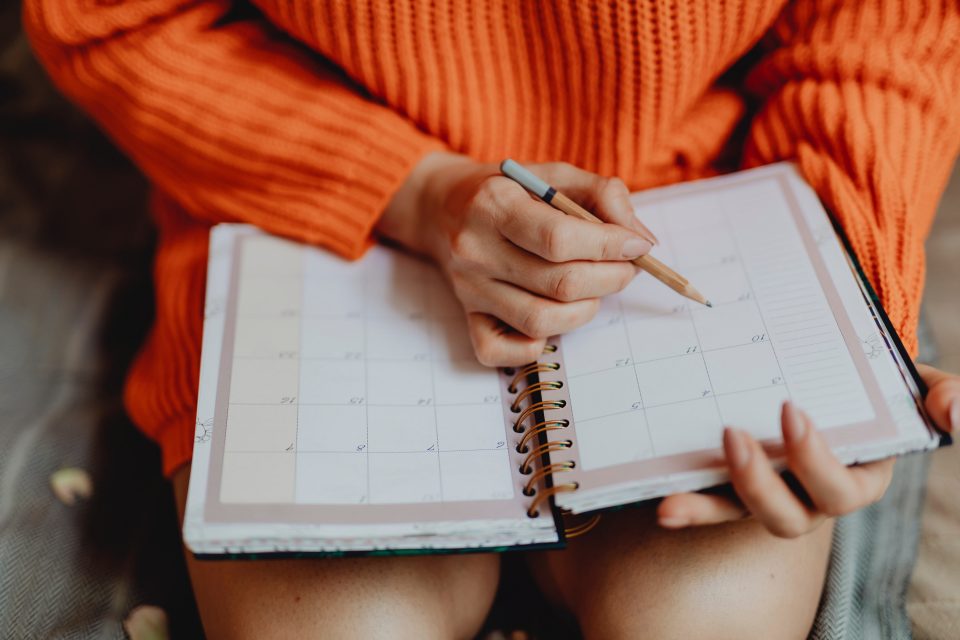 woman writing in a calendar