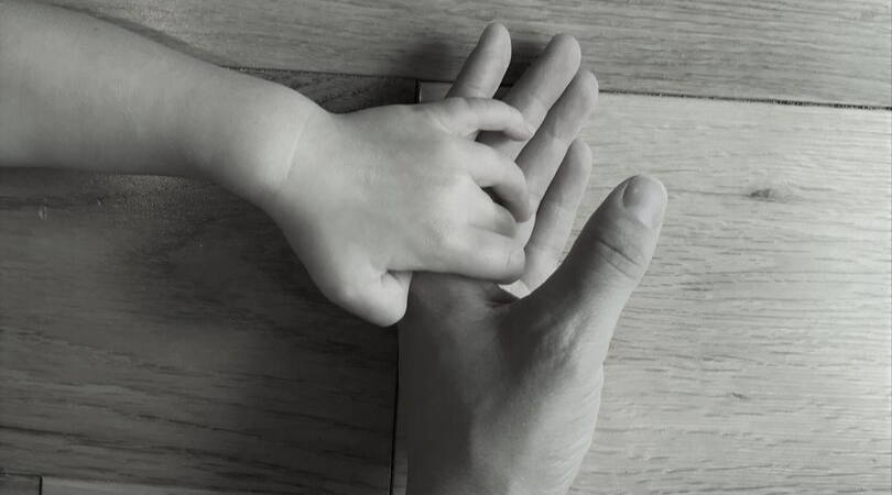 black and white photo of a mum hand holding a toddlers