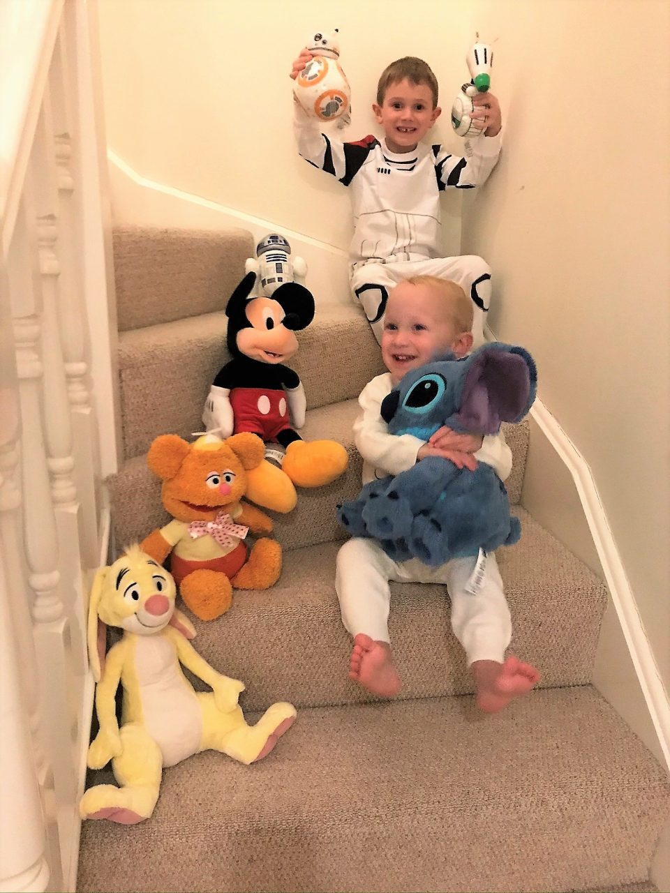 the boys sat on the stairs with all of their shopDisney products