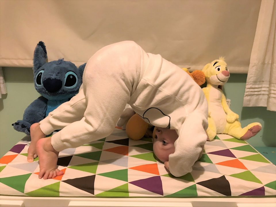 william doing a roly poly in front of his toys