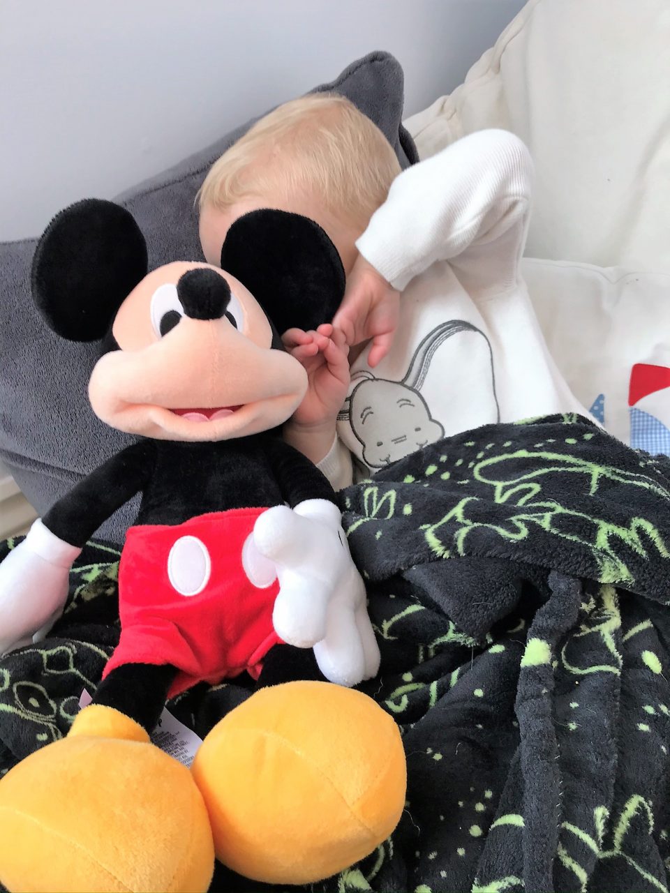 william hiding his eyes behind his mickey mouse toy