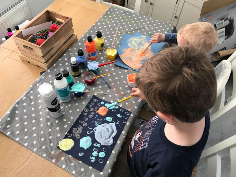 both boys using the foam to make planets