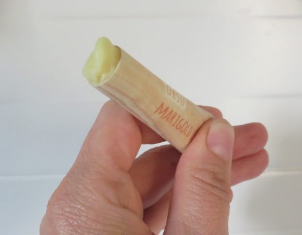 the lip balm in its packaging showing how easy it is to pop it up