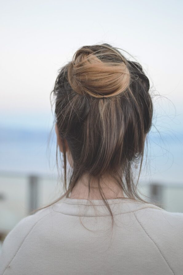 a messy bun on mousy brown hair