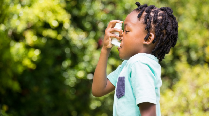 child with asthma taking an inhaler