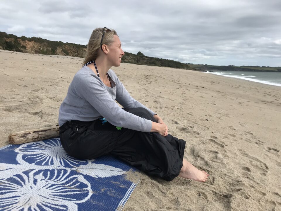 me sat on the beach wearing the Mozy looking out at the water 