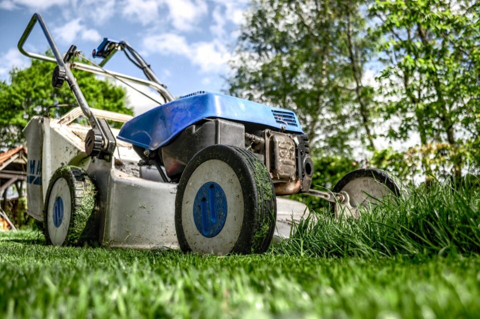 blue lawnmower cutting grass