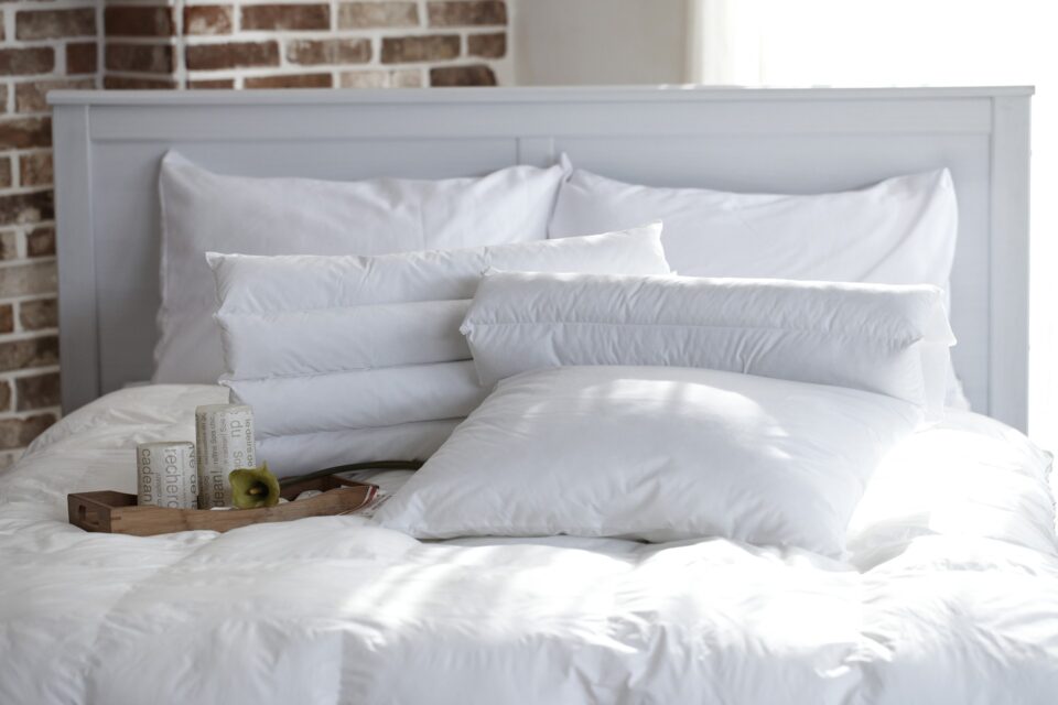 a white bed with pillows 