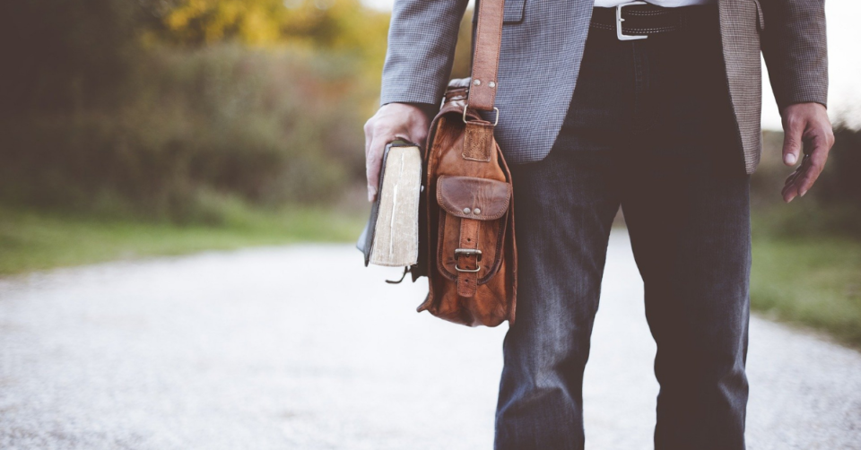a man with a book bag and holding books