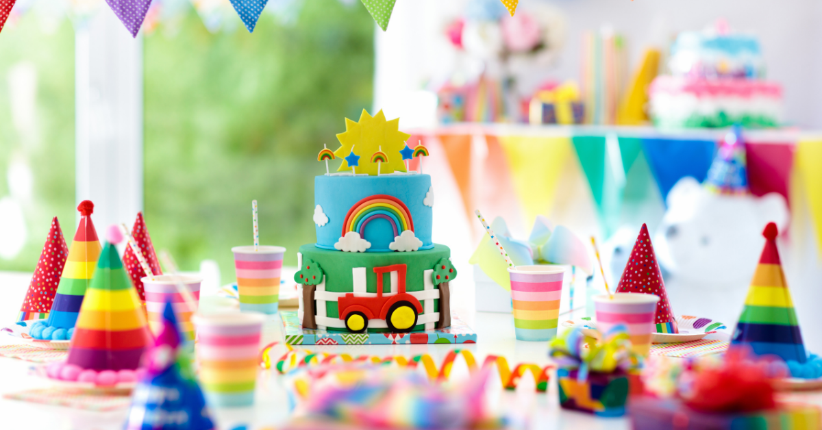 kids birthday party table with hats, cake and decorations