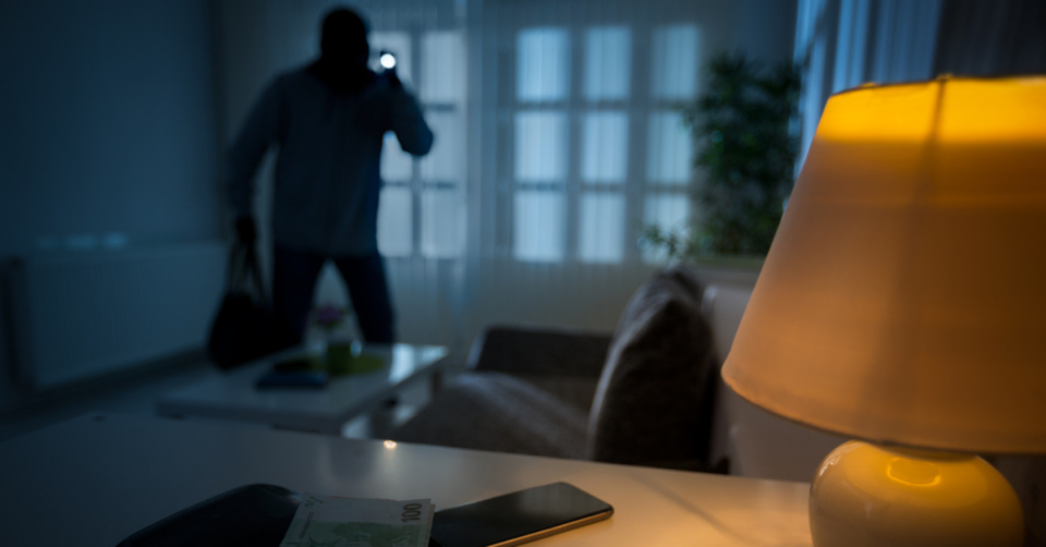 a thief breaking into a house at night