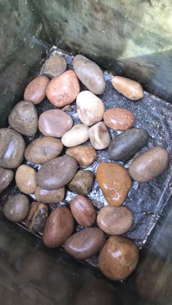 large pebbles in the bottom of the planter