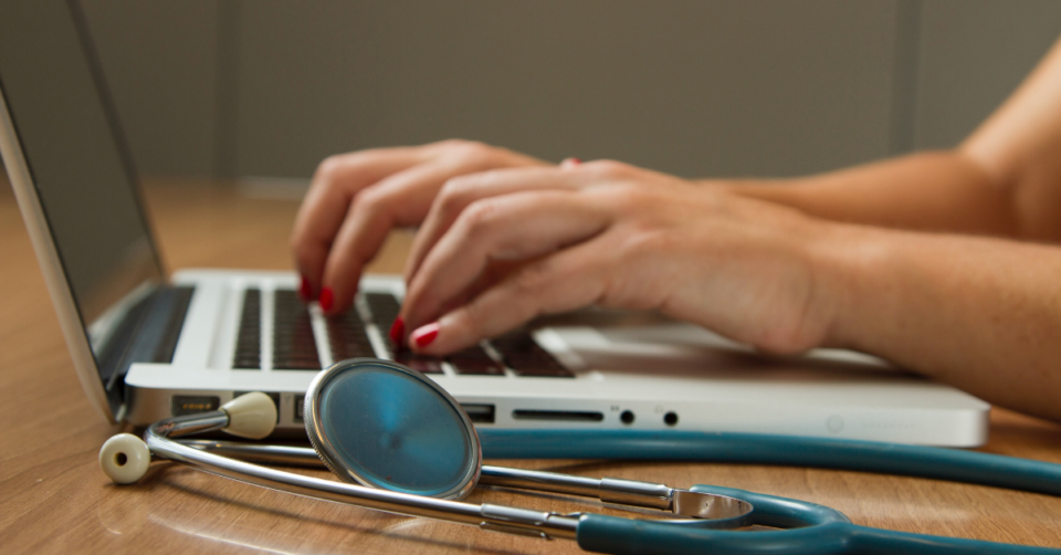 doctor typing on a computer