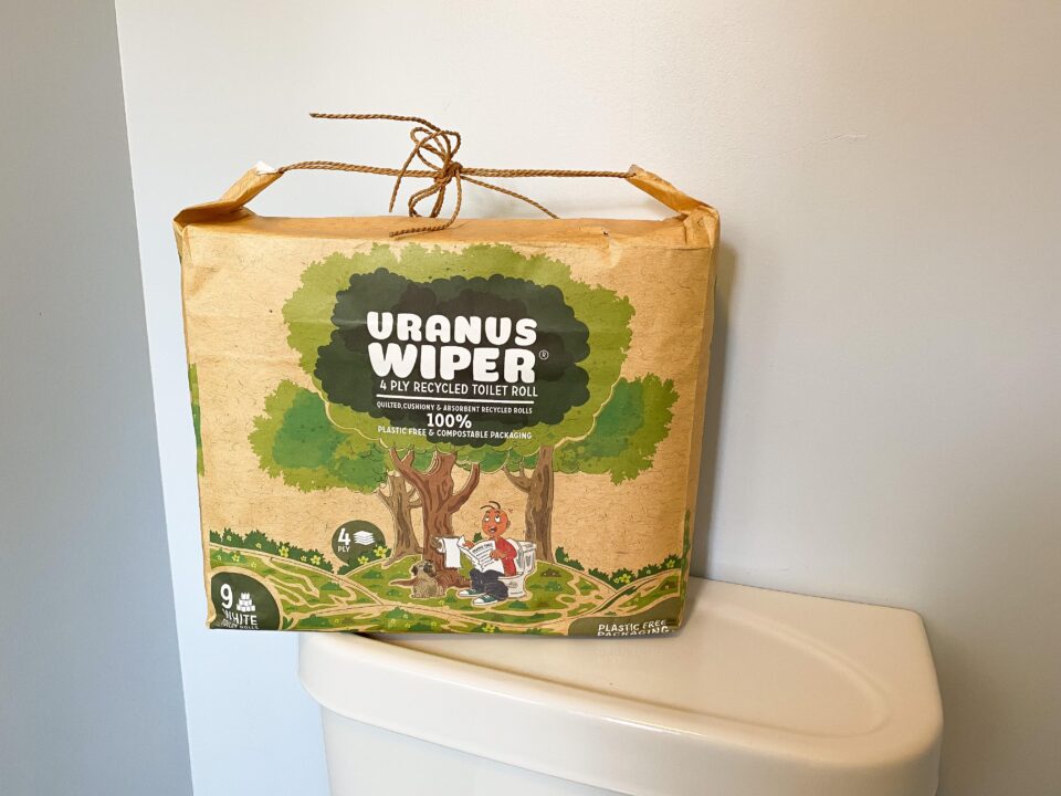 uranus toilet paper package sat on top of a toilet cistern
