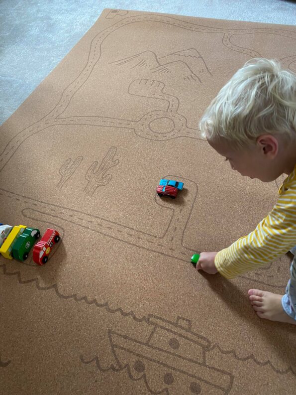 william playing with car toys on the Rocky Road Non-Toxic Play Mat