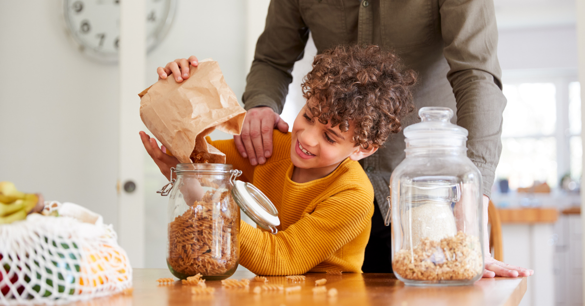 a child filling a jar with his dried food from a refill store