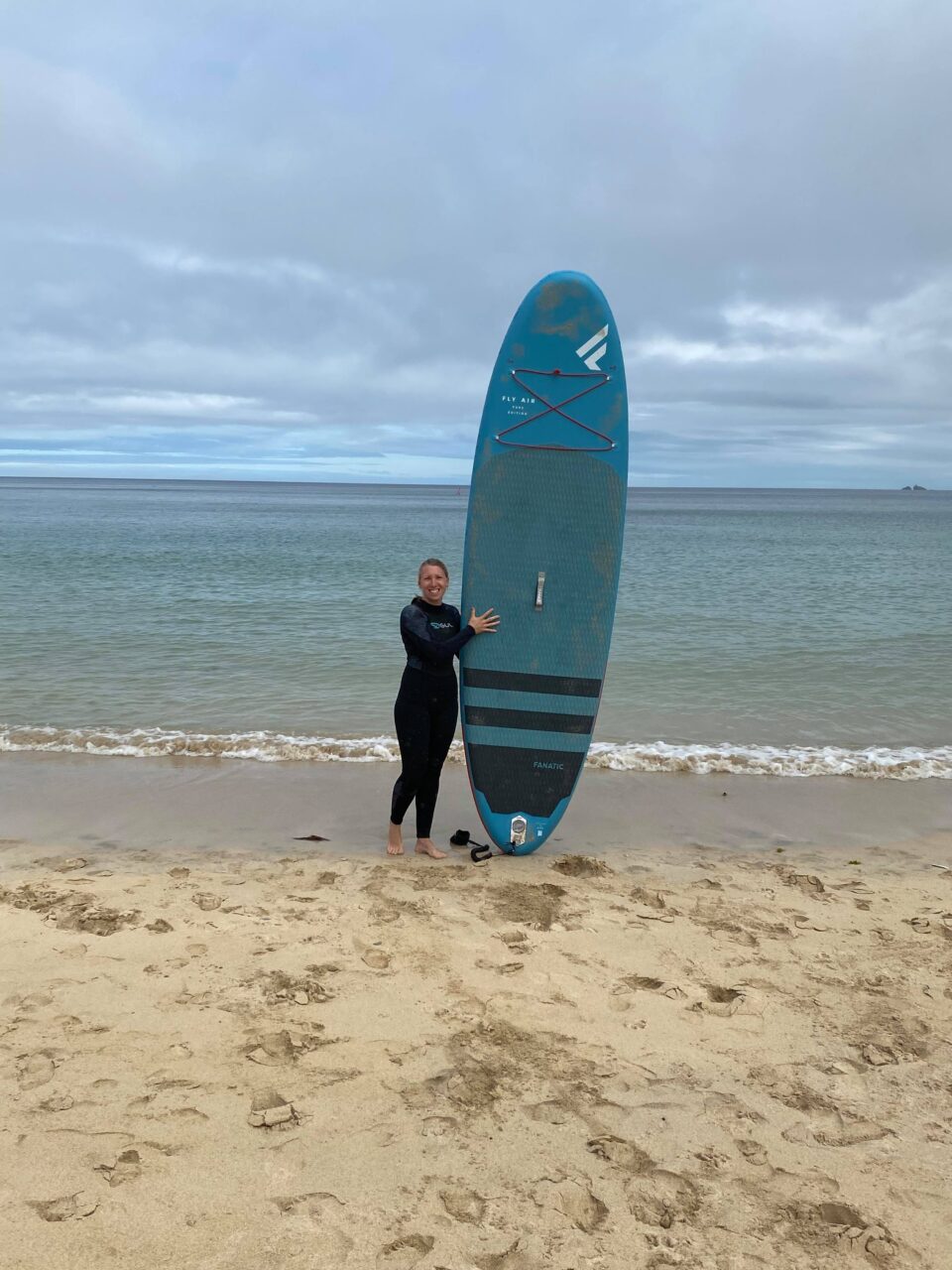 me holding paddleboard up on the beach