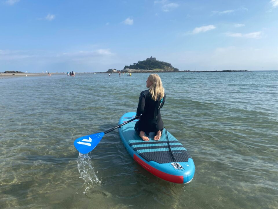 me kneeling on the paddleboard at St Michaels Mount in Cornwall