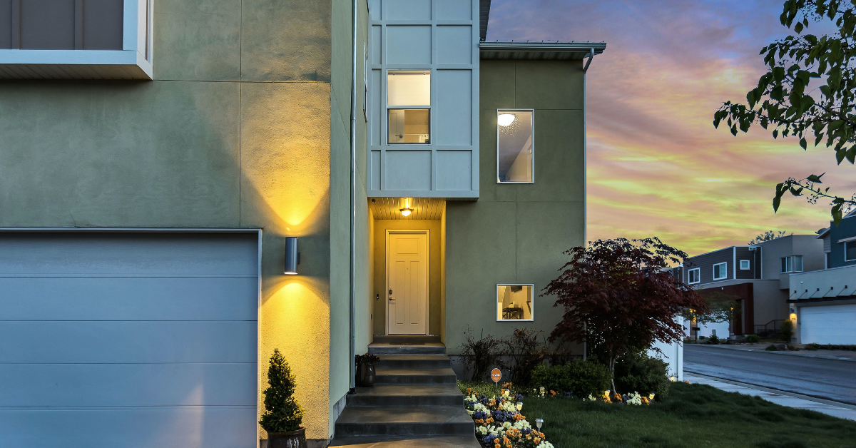 a house at the end of the day with a small garden and light on