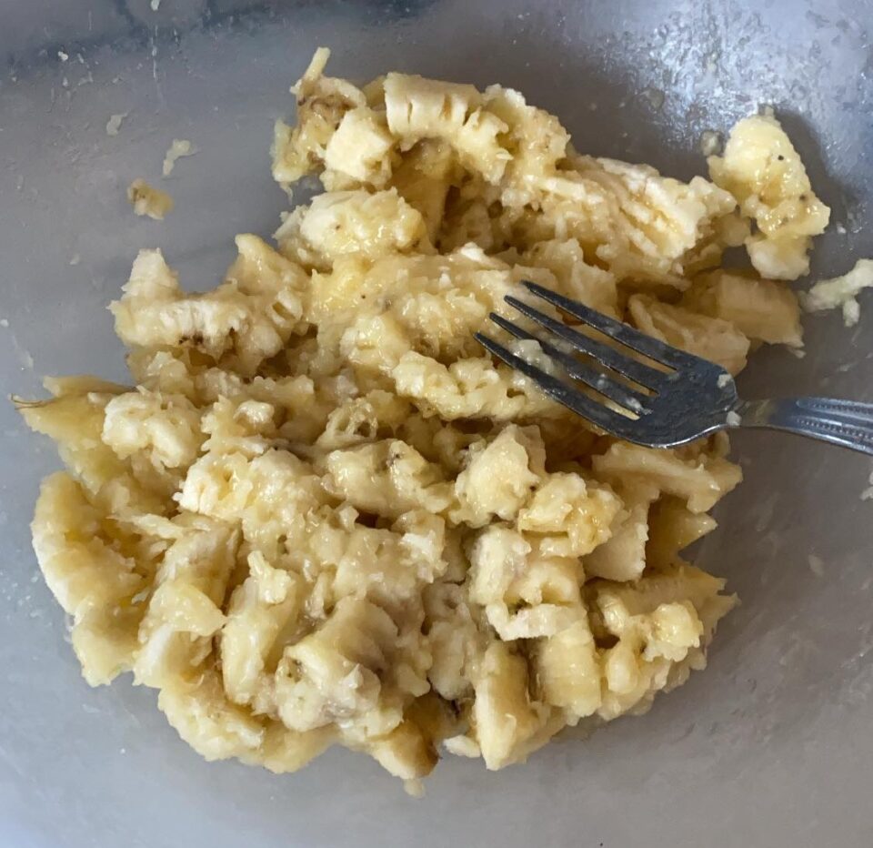 mushing the bananas with a fork to make banana bread