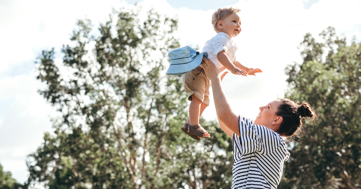 a mum lifting a baby in the air