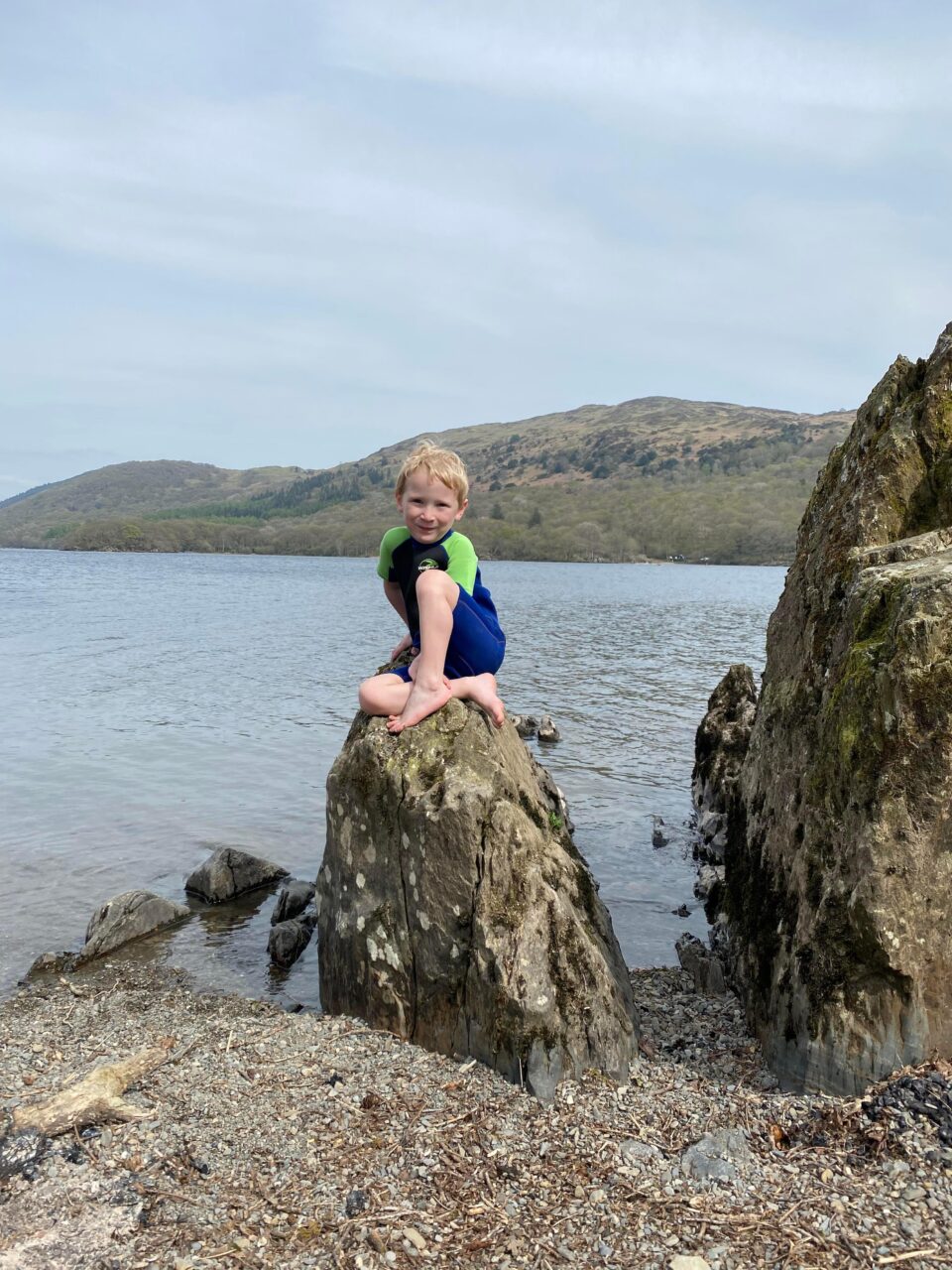 boy sat on rock by coniston