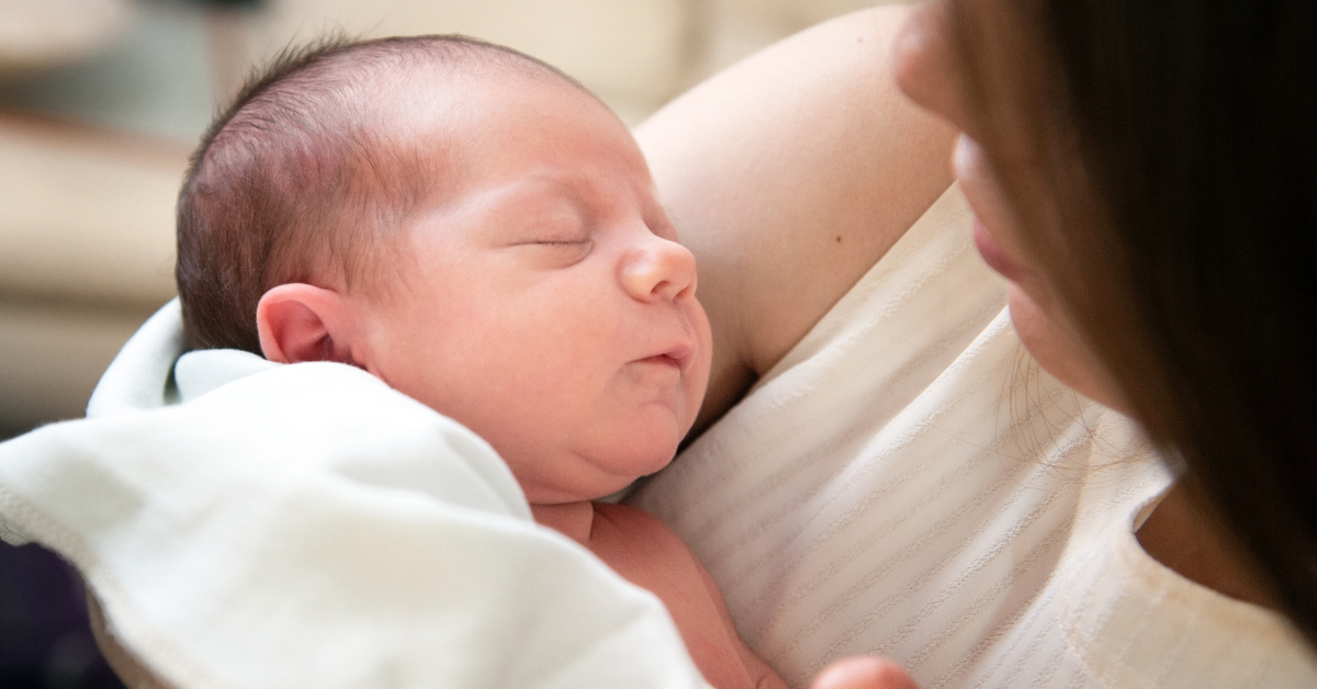 a baby asleep in a parents arms