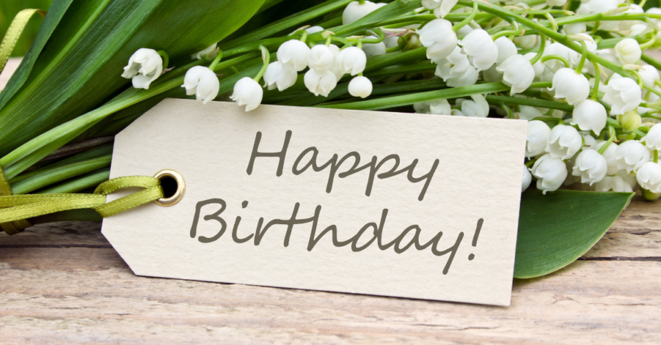 hapy birthday written on a card with white flowers next to it