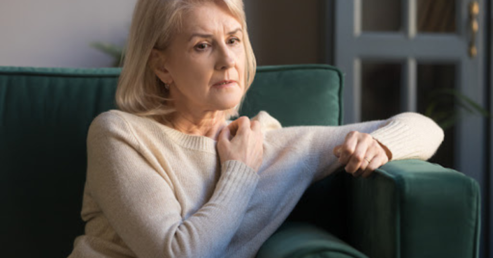 a lady sat on a sofa pondering