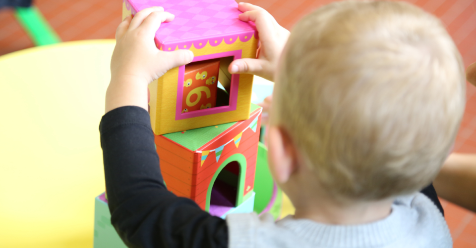a child stacking bricks in a play room