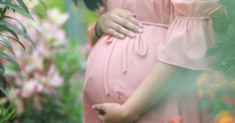 a pregnancy bump in a pink dress