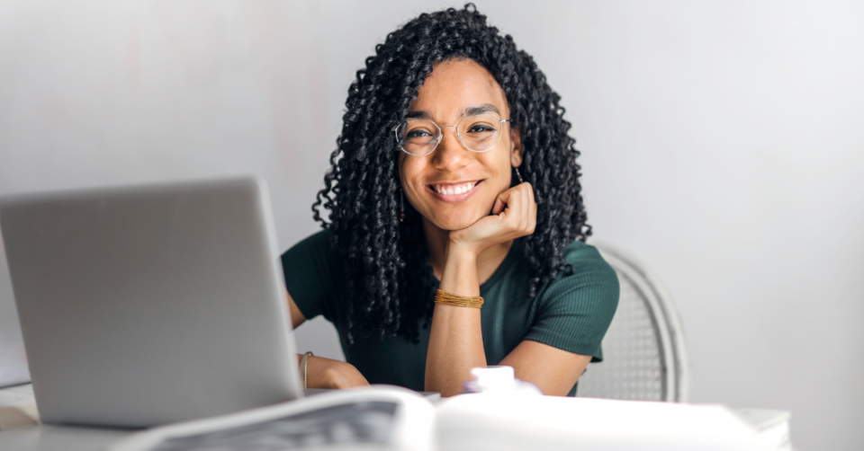 a woman sat at a laptop smiling