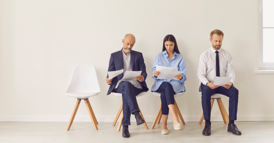 3 people sat on chairs waiting on job interviews presumably