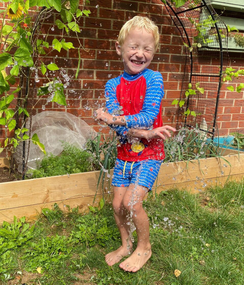 William being hit with the water balloon and water droplets shown everywhere