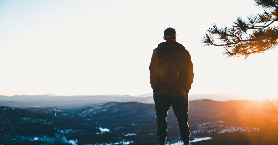 a man standing looking over mountains