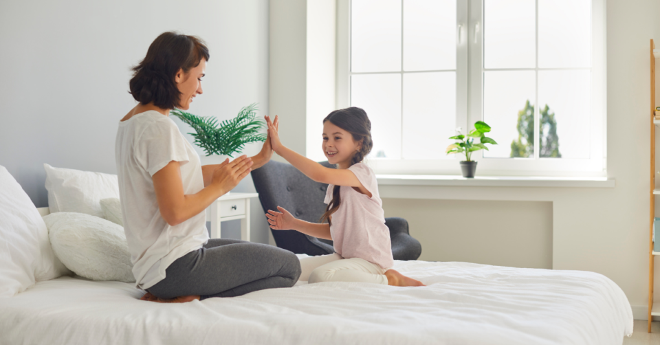 mother and child playing on a bed