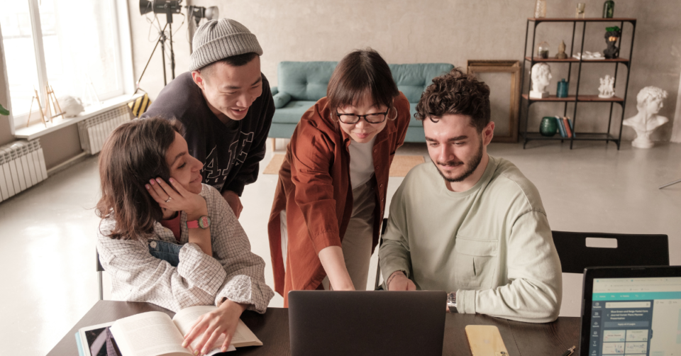 4 people looking at a laptop