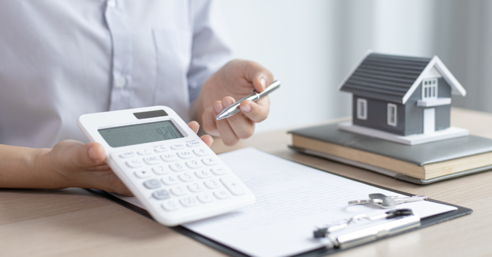 a man holding a calculator and showing money in reference to a mortgage