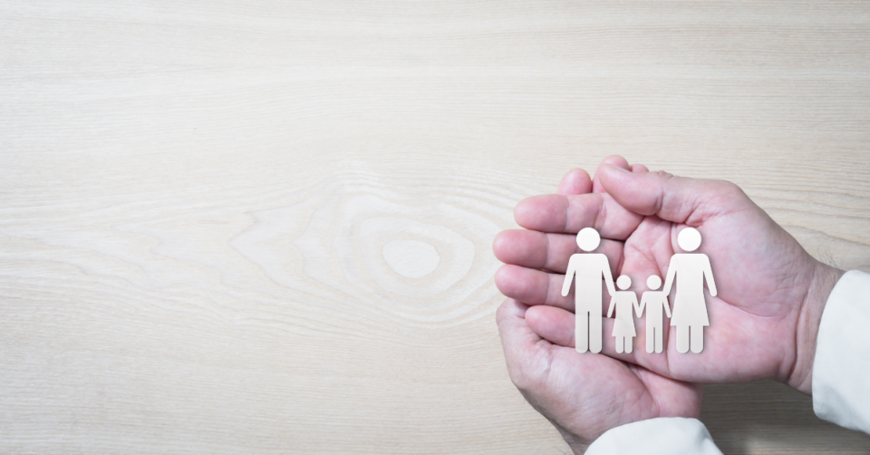 a hand holding a cut out family