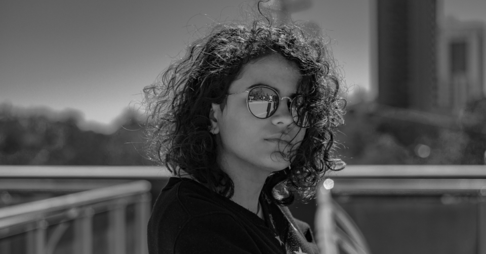 black and white photo of a lady with wavy hair wearing sunglasses