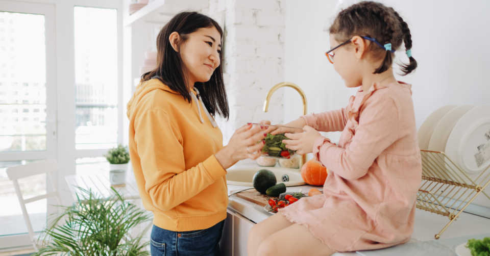 a mum and child reaching for veg
