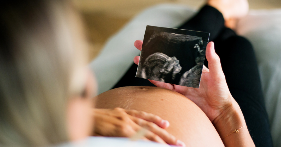 pregnant woman looking ar her scan